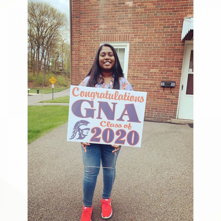 Ms. Victor holds a class of 2020 sign