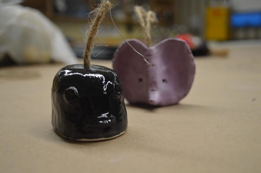 From left to right: A black ornament shaped like a fish, a purple ornament shaped like an elephant. Both are available for purchase.